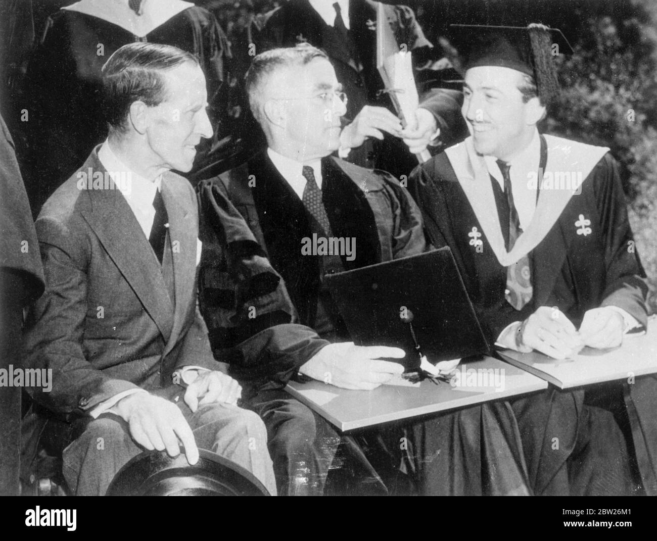 Walt Disney and lord tweedsmuir receive Harvard Degrees. Walt Disney, creator of 'Mickey Mouse', and Lord Tweedsmuir, Governor General of Canada, were among the recipients of honorary degrees at Harvard University, Cambridge Massachusetts, USA. Photo shows, left to right, lord Tweedsmuir (Doctor of Laws), Irving Langmuir, research chemist (Doctor of Science) and Walt Disney (Master of Arts). 2 July 1938 Stock Photo