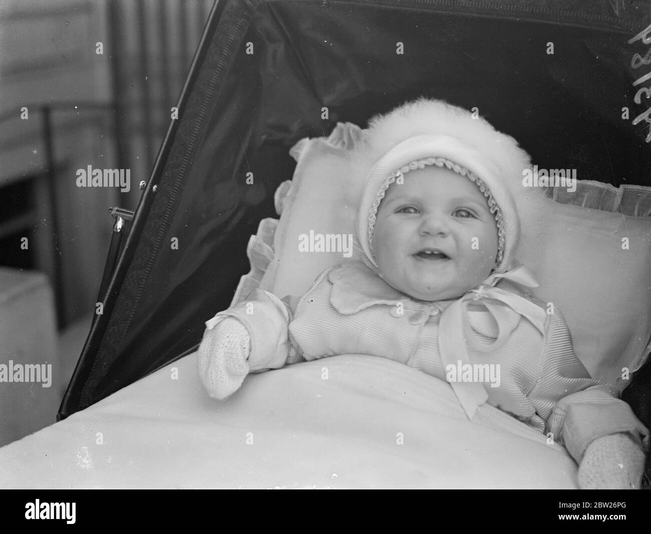 Lord and Lady Herbert's baby daughter goes out in a white woollies. Diana Mary, the baby daughter of Lord and Lady Herbert, proudly showing her two teeth as warmly wrapped up in her white woollies she set out from her home in Eaton Square for an airing. Diana's first birthday will be celebrated on 19 April. 29 January 1938 Stock Photo