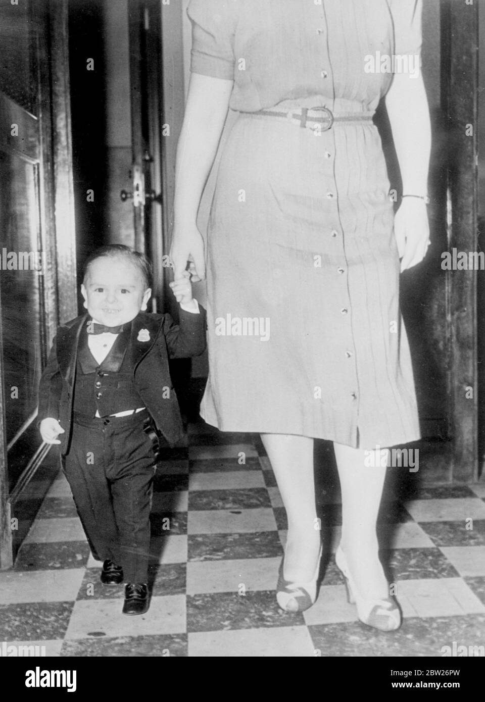 World's smallest man in New York. Paul de Rio, the world's smallest man, who is only 19 inches tall, is to be presented at the Million Dollar Pier in Atlantic City, New Jersey. Paul was born in Spain 18 years ago and only weighs twelve pounds. Photo shows, Paul de Rio makes a woman of normal stature appear a giantess as he walks with her at his New york Hotel. Stock Photo