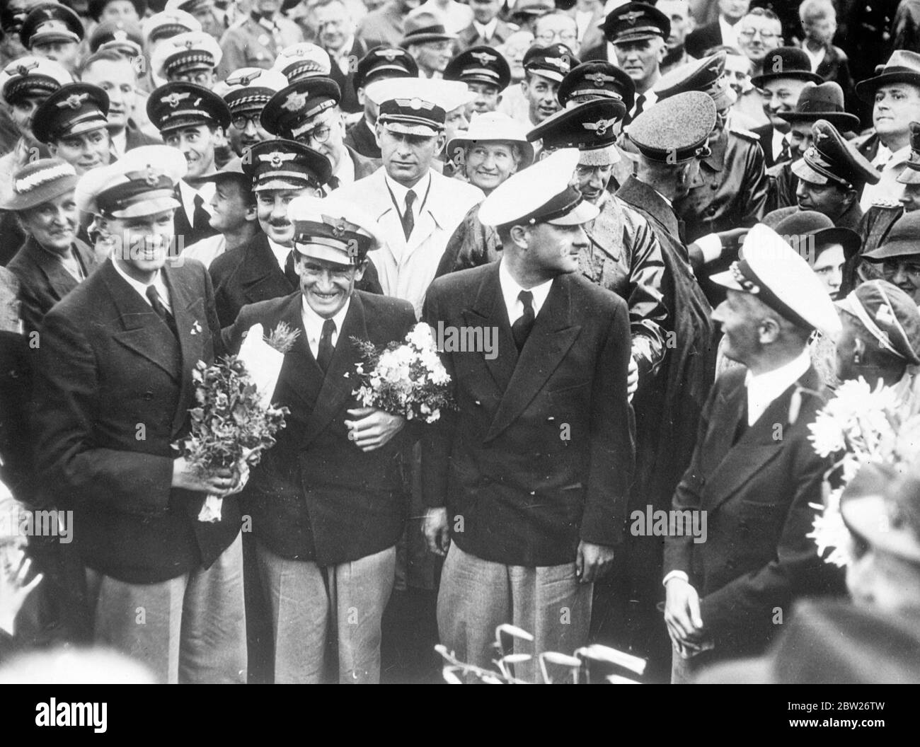 German aircrew welcomed home after record-breaking Atlantic flight. The German airliner 'Brandenburg' which had flown from Berlin to New York in 24 hours 56 minutes, landed at Tempelhof Aerodrome, Berlin, after they return flight of 19 hours 54 minutes. This was the fastest flight from New York to Berlin and easily beat the record set up by the round the world flyer Wiley Post in 1933, of 24 hours 45 minutes. The crew of the machine, Captain Henke, Captain von Moreau, Radio Operator Kober and Mechanic Dierberg, were given a tremendous welcome home, and were received at the Air Ministry by Gene Stock Photo