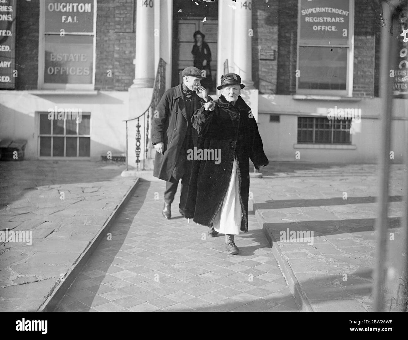 Friends of 51 years married at London register office. Mr Henry Bailey, a Kennington greengrocer, and miss Mary Ann Kitchener, who have known each other for 51 years and have been neighbours for most of that time, were married at Lambeth register office. Photo shows, Mr Henry Bailey and his bride, leaving the register office, after their wedding. 24 January 1938 Stock Photo