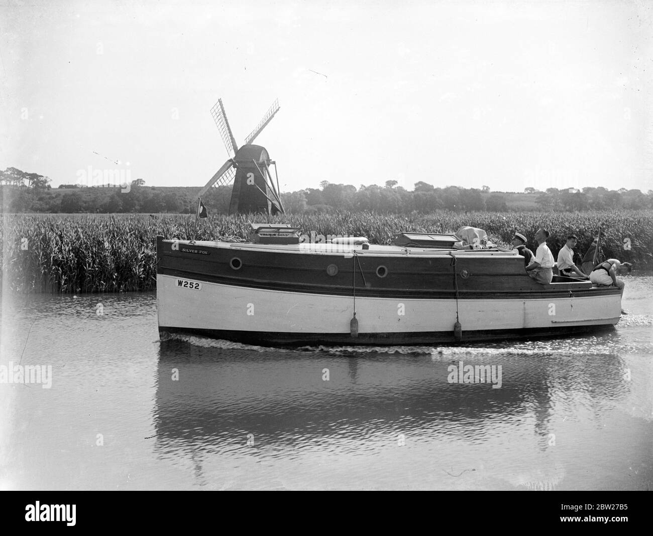 Young men and women sailing through The Broads. 1933 Stock Photo