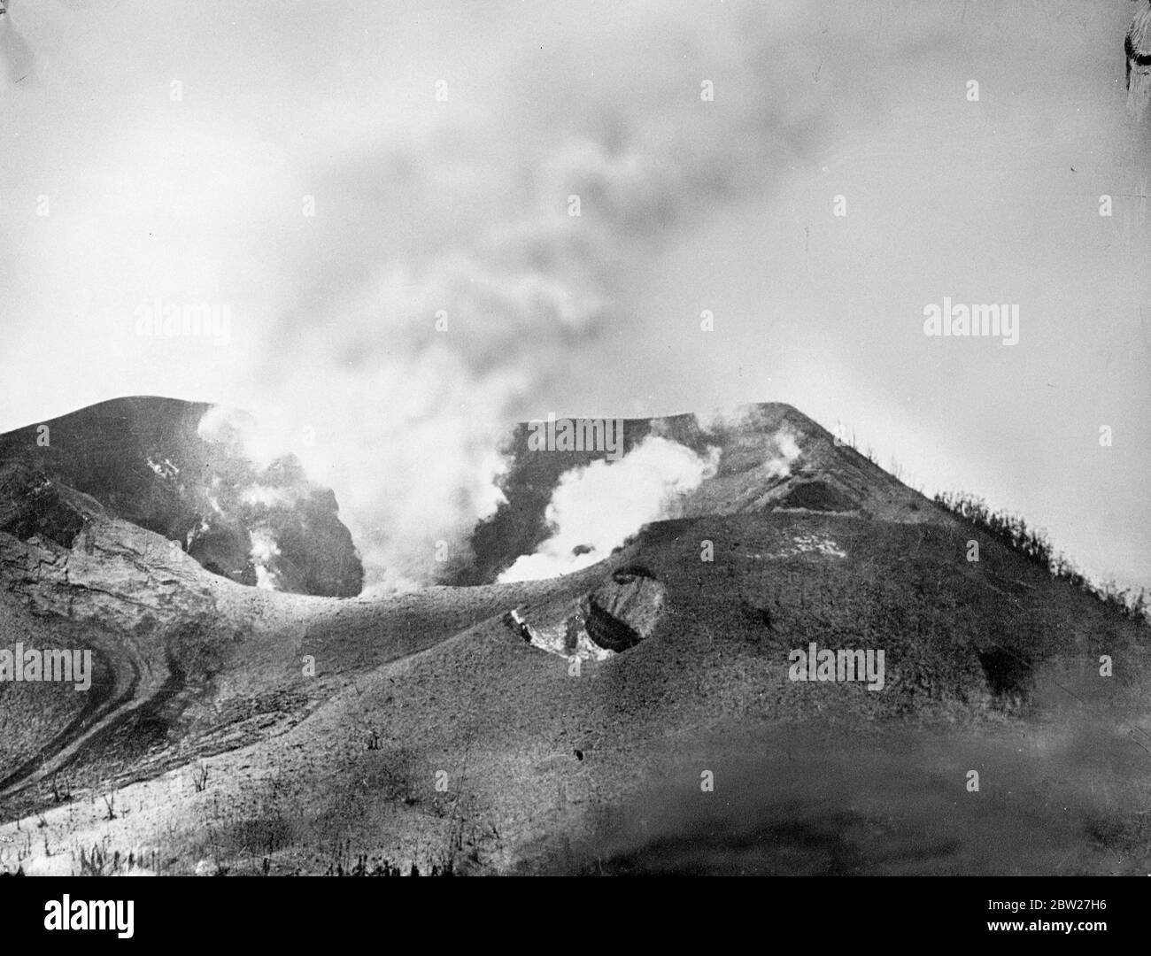 Smoke and volcanic mud pouring from the crater on Matupi Island. First pictures of volcano disaster on New Guinea islands. Three volcanoes, 2 on Vulcan Island and one on the Matupi Island, erupted violently showering pumice and mud on the roofs of Rabaul chief town of New Britain Island in New Guinea. A state of emergency was declared. 18 June 1937 Stock Photo