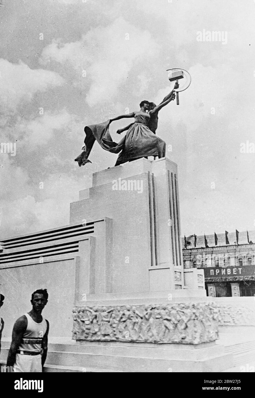 The model of the Soviet pavilion being carried in the parade. Life people represent the figures of the worker and the collective farm woman which surmount the tower. 40,000 athletes from 11 republics paraded triumphantly across red Square in a great display to celebrate the 20th anniversary of the revolution. 18 July 1937. Stock Photo