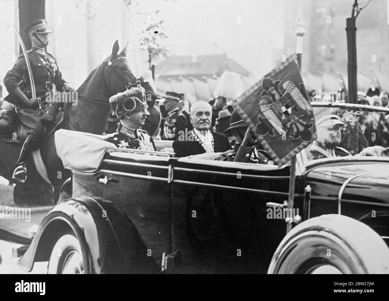 King Carol of Romania (left), who with Crown Prince Michael is visiting Warsaw, driving through the city to the Royal Palace with President Moscicki of Polland (right). 30 June 1937 Stock Photo
