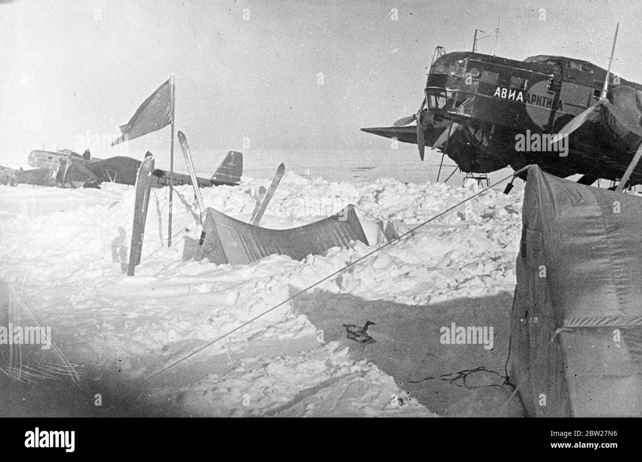 The giant planes of the polar expedition on the ice beside one of the tents at the North Pole. The Russian scientists are conquering the legendary land of ice and snow on top of the world that is still uncharted. They have settle down for a year's stay on an ice floe at the North Pole and are now making whether surveys. 2 July 1937 Stock Photo