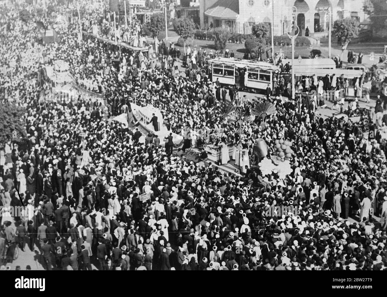 The wedding of King Farouk in Cairo. With traditional Muslim ceremony, 17-year-old King Farouk of Egypt, was married at the Koubbeh Palace in Cairo, to Miss Farida Zulficar Pasha, the judge of the Egyptian court of appeal. Photo shows, Huge crowds watching the procession of decorated floats from the Abdin Palace to the Koubbah Palace as all Cairo joined in the wedding celebrations. 23 January 1938. Stock Photo