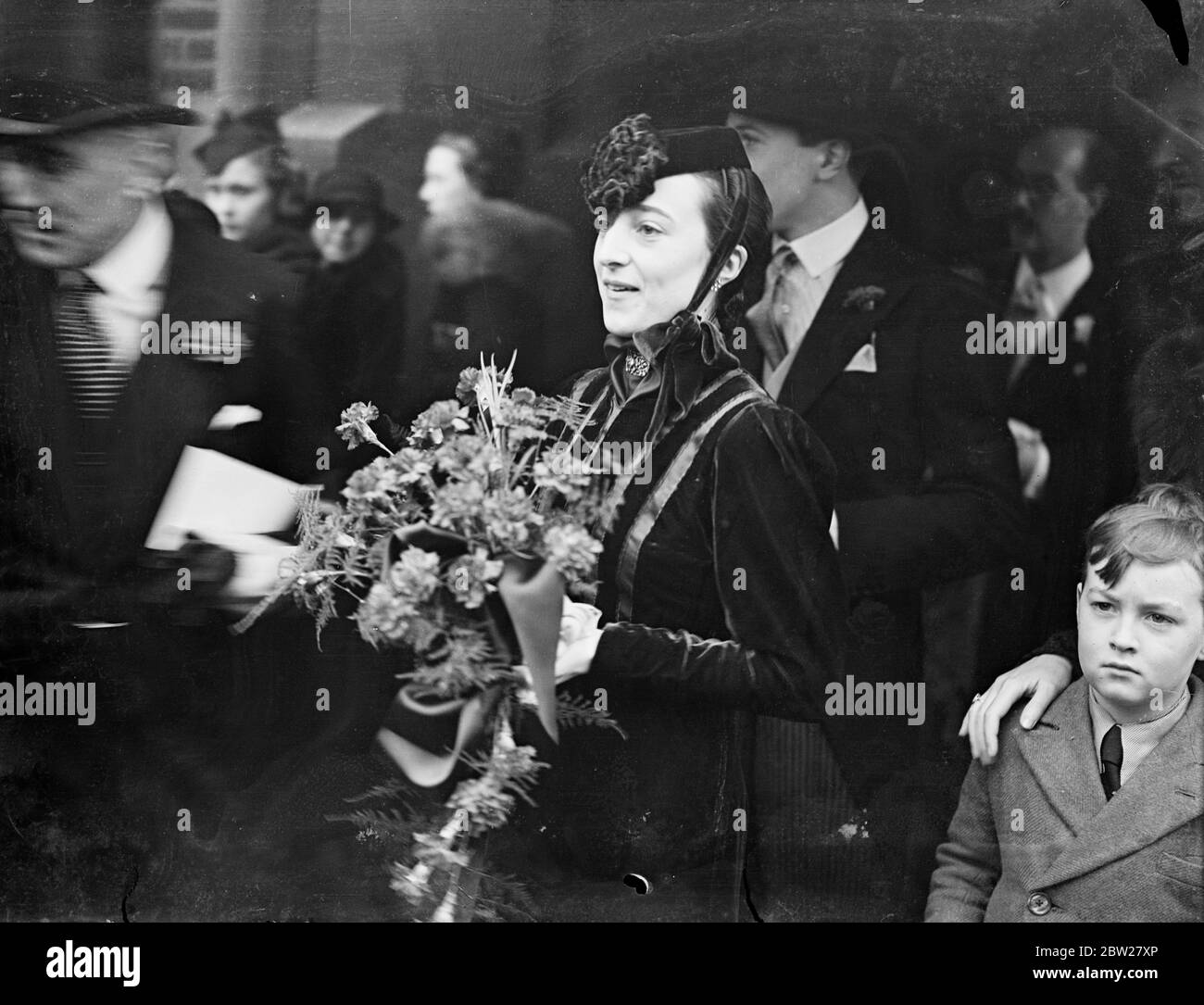 Pillbox hat fashion at London turf wedding. Mrs Barbara Robb, chief bridal attendant, wearing a novel 'Pill Box' hat fashion which ties beneath the chin, after the wedding at St Mary's Church, Cadogan Street, London, of Miss Constance Dagnell and Major George Anne, managing director of Tote Investors, Ltd. 22 Janary 1938 Stock Photo