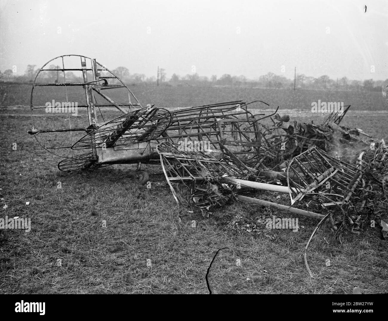 Three die when RAF and civil plane collided over Hertfordshire. Planes crash in brickworks. Three men, an RAF officer and a pilot instructor and pupil were killed when a Gloucester Gauntlet Plane from Duxford and a de Havilland Tiger Moth plane collided in midair and crashed in flames at Smallford, near St Albans, Hertfordshire. The service plane fell in a field adjoining a brickyard and the civil machine, crashed into a gravel pit, causing 20 men to run for their lives. Photo shows, the tangled wreckage of the RAF plane in the field. 21 January 1938 Stock Photo