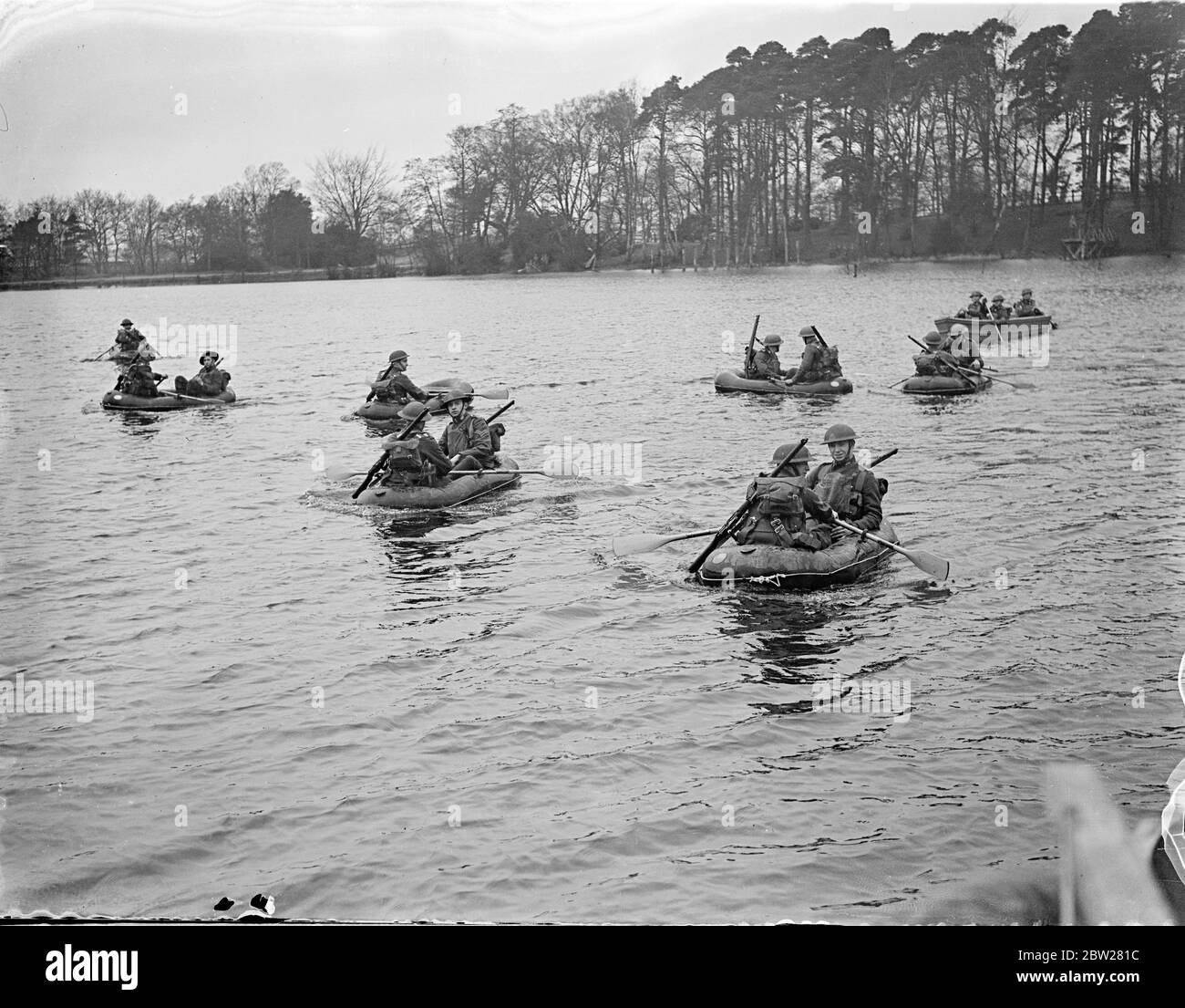 Troops ford Lake in aero boats at Aldershot demonstration. Latest equipment and training methods of infantry detachments of the British Army demonstrated by the first Battlalion the South Staffordshire Regiment in a series of exercises at Mytchett, near Aldershot, Hampshire. Photo shows, , troops fording Mytchatt Lake in pneumatic Aero Boats. The boats, which can be folded into a small space, carry two men with their equipment. 21 January 1938 Stock Photo
