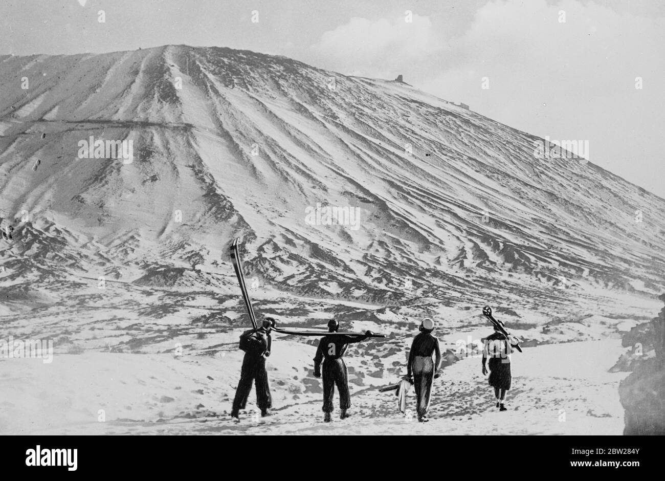 Skiing on the Vesuvius for the first time in years. The intense cold has covered Vesuvius with slow for the first time in many years and skiing enthusiasts from Naples are now enjoying good sport on the slopes of the volcano. Photo shows, skiers approaching snowclad Vesuvius. 14 January 1938 Stock Photo