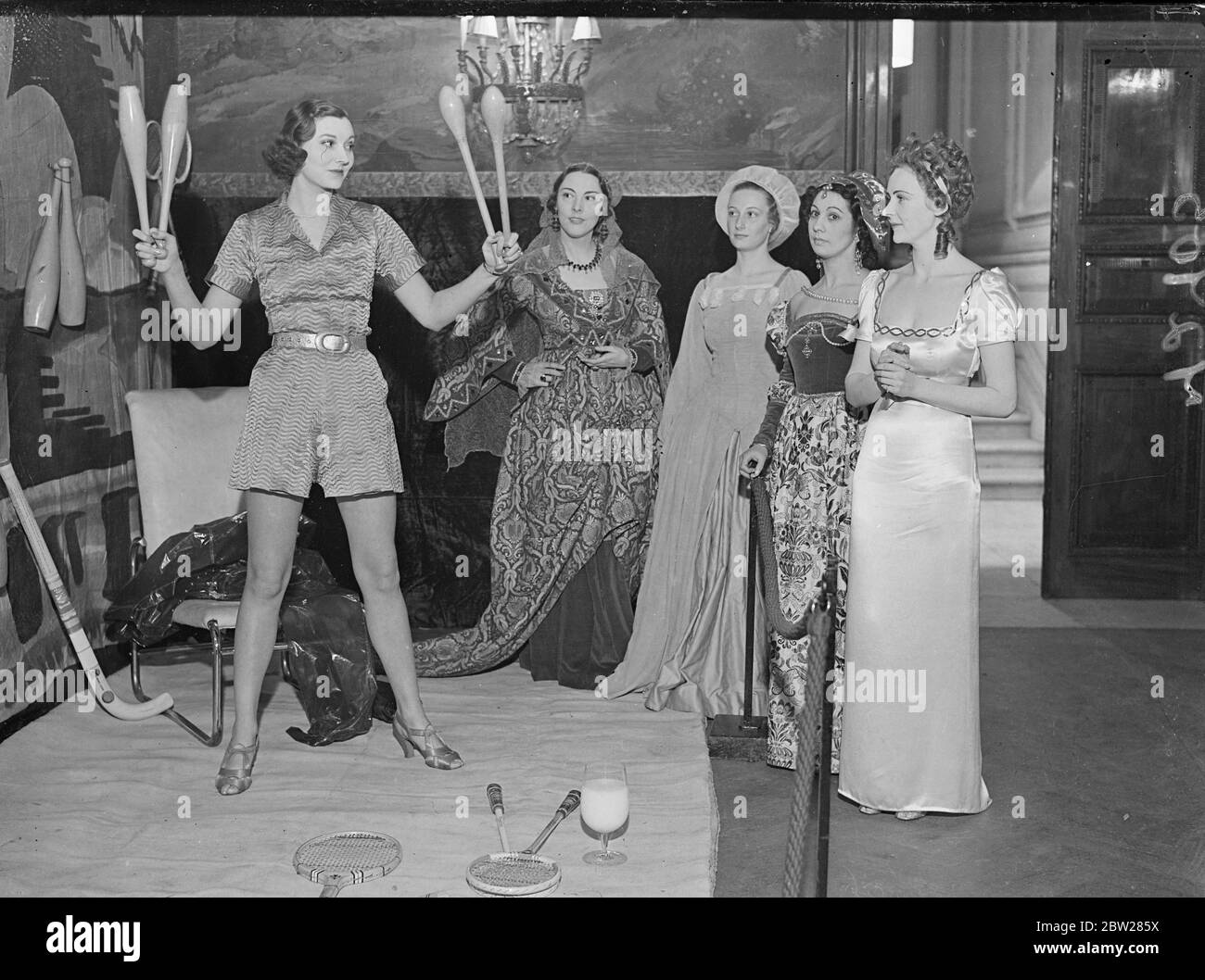 Beauties of the past. The beauty of the future in London. Well-known women, in costume, are appearing as beauties of bygone days at the Palace of Beauty which has opened at Grosvenor Square, London, in aid of Battersea General Hospital. Photo shows, left to right, Lucretia Borgia (Miss Snowden), Lady in Waiting (mrsClifford Wight), Diana de de Poitiers (Miss Zita Whitley) and Madame Recamier (Miss E Ripper) watching the Beauty of the Future (Miss Zoe Rogers). 12 January 1938 Stock Photo