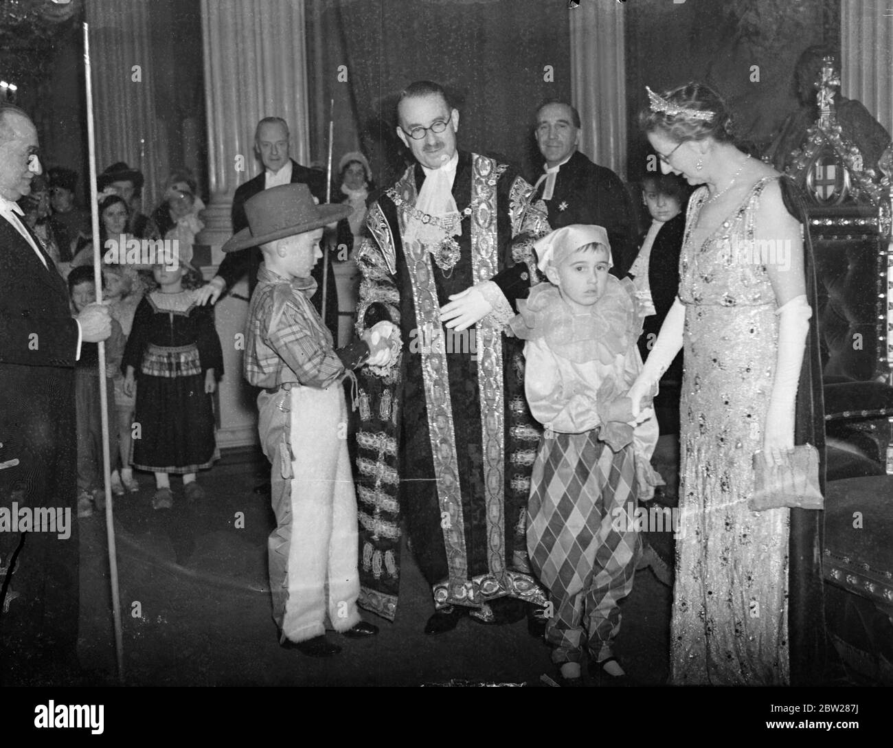 Lord and Lady Mayoress received guests at children's bail. Over 1000 children fancy dress with a guest of the Lord Mayor of London, Sir Harry Twyford, and the Lady Mayoress, at a Ball at the Mansion House, London. Photo shows, the Lord Mayor and Lady Mayoress , receiving the guests at the mansion house. 6 January 1938 Stock Photo