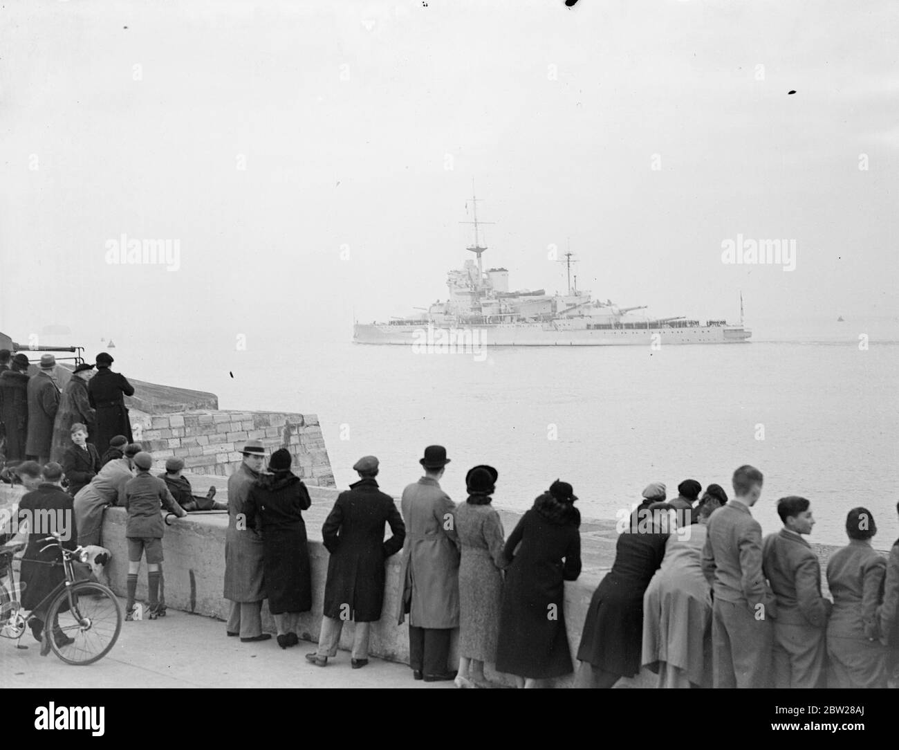 HMS Warspite sails for Mediterranean after four delays. After four delays, three owing to mechanical troubles and the last through fog, reconditioned 31,100 ton battleship 'Warspite' left Portsmouth for the Mediterranean, where she will become the flagship of Adml Sir Dudley Pound, the commander-in-chief. 'Warspite' has been entirely refitted since 1934, at a cost of Â£2,362,000. Photo shows, 'HMS Warspite' leaving Portsmouth for the Mediterranean watched by crowd. 5 January 1938 Stock Photo