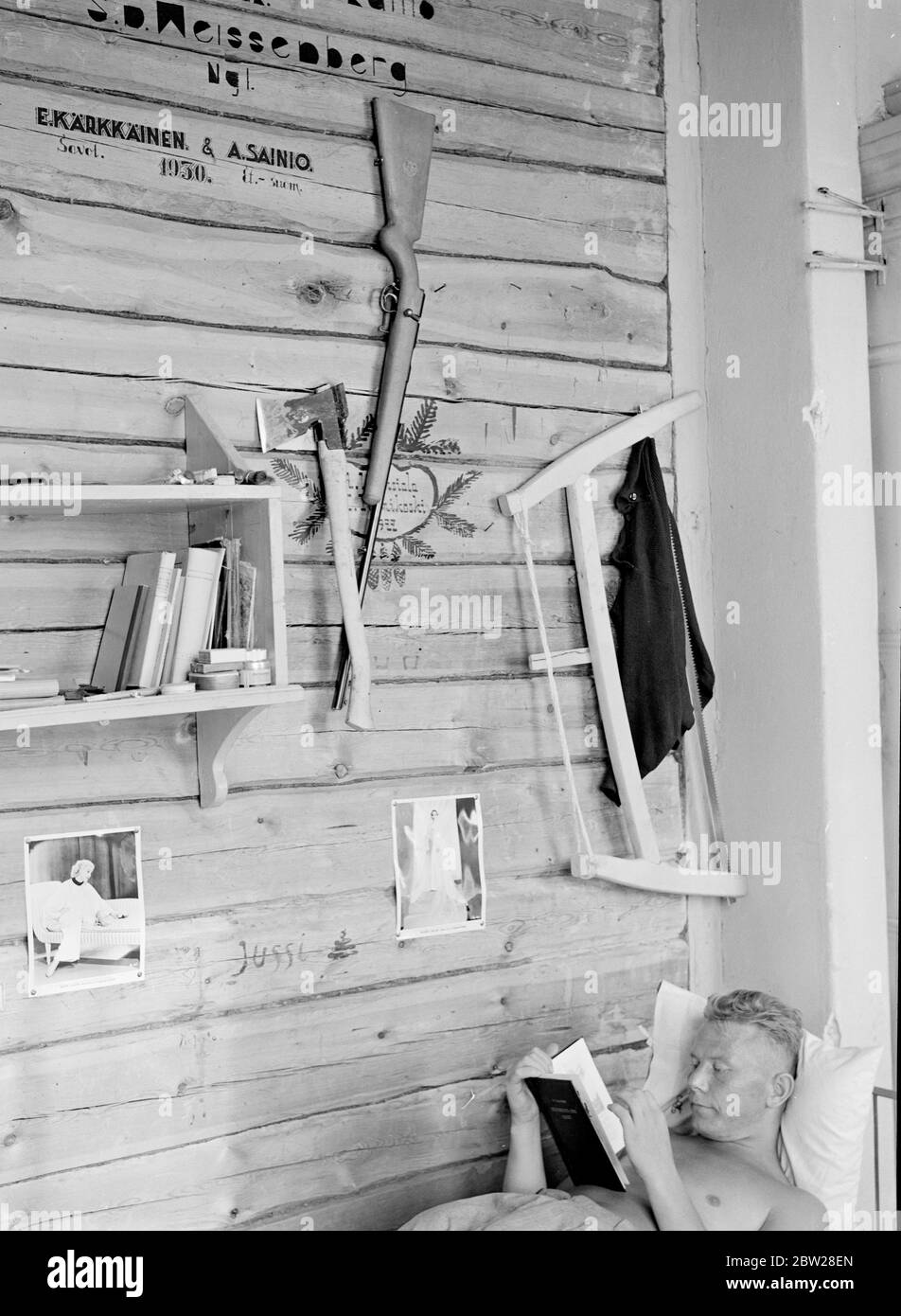 Worlds greatest foresters. Finland - Finnish daily life Forest Academy of Korkeakoski 1939 Gun, axe, saw - and american film stars. Korkeakoski's summer school of forestry is 5 miles from the station and 200 miles from Helsinki. There are no cinemas, no dancing places, yet there are 60 muscular and healthy young men whose only entertainment is an occasional dip into the lake. No wonder then that next to the bed of most of the students is a hollywood pin up. From a series These Men Built the Mannerheim Line - the Finnish zone of frontier fortifications was designed and constructed entirely by t Stock Photo