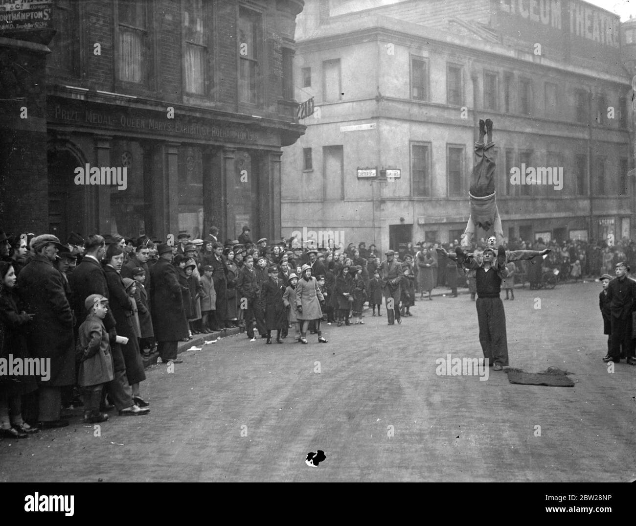 The extra show for Boxing Day pantomime queues. 'Buskers' providing additional entertainment for the Boxing Day queues waiting outside the Lyceum Theatre to see the pantomime 'Beauty and the Beast'. 27 December 1937 Stock Photo