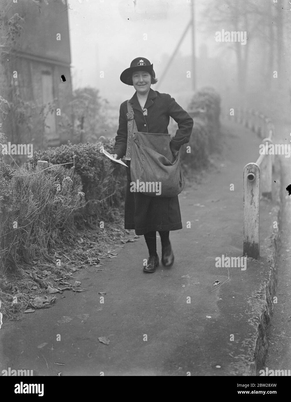 One woman walking Post Office in Kent. Miss Grace Coles, of Wrotham, Kent, is an auxiliary postwoman and a travelling Post Office as well. She walked miles each day delivering letters to people living in remote parts of North Kent Downs, and also sells stamps and postal orders on her around and clicks letters and parcels from houses. Her round starts on the Pilgrim's Way and ends at Labour in Vain Hill. She walks more than 2500 miles a year. Photo shows, Miss Grace Coles on her round. 7 December 1937 Stock Photo