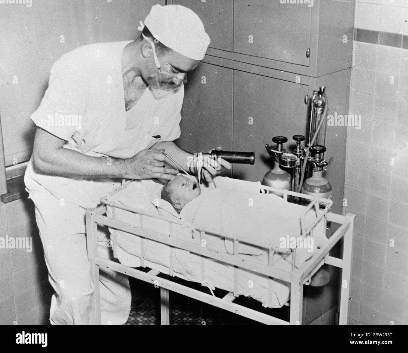 Doctor brings newly born dead baby to life. A baby whose heart stopped beating. Just before it is born, was bought back to life by the scale of Dr Arthur Smith, obstetrician at the Margaret Haig maternity hospital in Jersey City, New Jersey, USA. Just before delivery. The doctor discovered that the baby's heart had stopped beating. He administered five drops of adrenaline when the baby was born, apparently dead. After five minutes respiration. The baby drew its first breath and was placed in a tub of warm water. In his first few minutes of life. The baby was given a mixture of 5% carbon dioxid Stock Photo