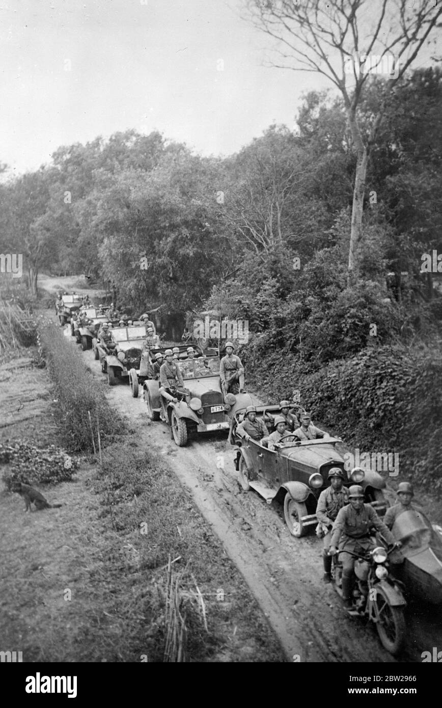Driving to block path to Japanese 'steamroller'. Picture just received in London of a procession of Chinese army cars steering, a rough passage over a narrow road in the Soochow District, Wester Shanghai, as Chinese forces struggle to hold up Japan's victorious sweep onwards to Nanking. As China strives to block Japan's path, a new situation has arisen in conquered Shanghai, where the Japanese are taking control of the customs and incurred the opposition of Britain, America and France. 28 November 1937 Stock Photo