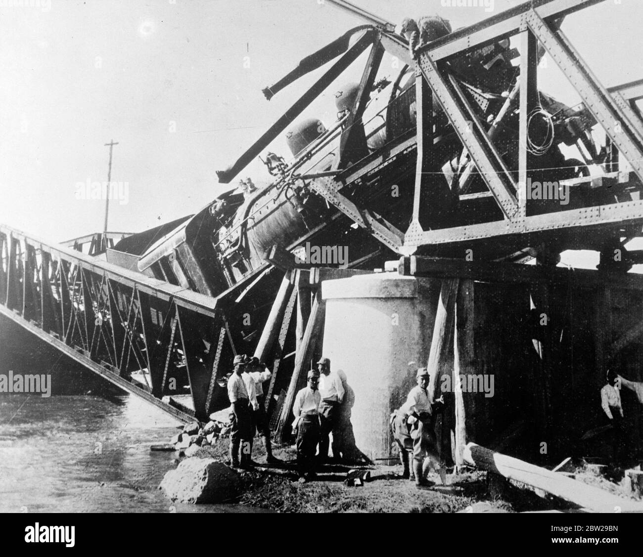 Chinese bombed Japanese railway in China. Engine. Through wreckage of bridge. Reversing the usual procedure in China bombing raids, Chinese air and followed the tactics of the Japanese bombed a railway engine as it was crossing a bridge on the Japanese operated section of the Peking and Hankow railway. The Chinese bomb squad a direct hit on the bridge and the engine punch through the wreckage. Photo shows, the Japanese engine amid the wreckage of the bridge. 13 November 1937 Stock Photo