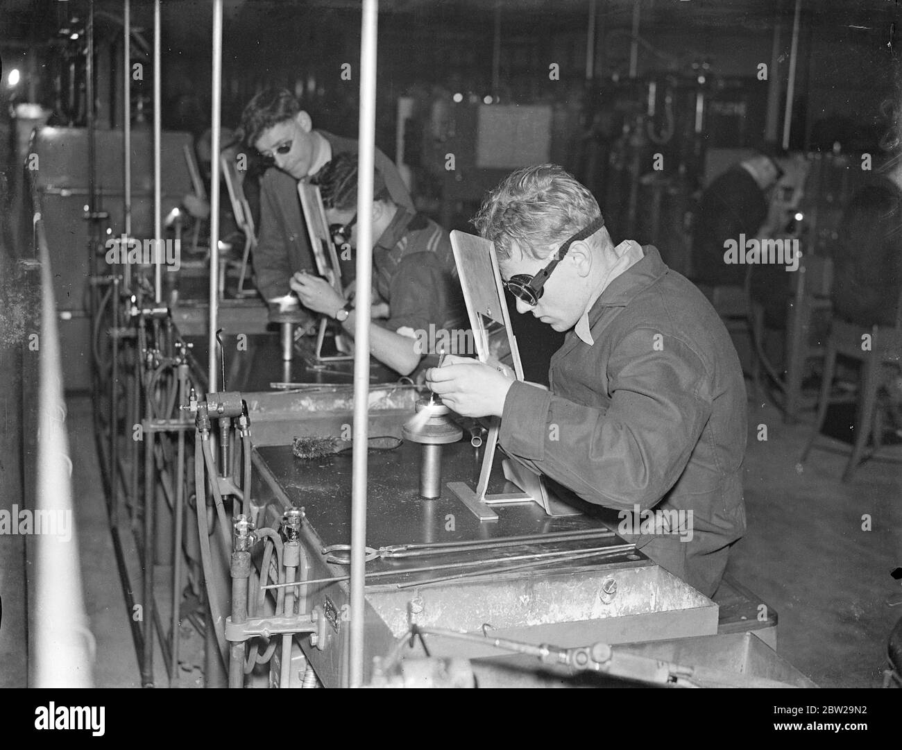 'Shadow factories'silent allies of Britain's Air Force. This series of pictures is the first ever made in Britain's 'shadow factories'the centres organised among motor manufacturers throughout the country to aid the Royal Air Force expansion scheme. Less than a year ago the 'shadow factories'were only an idea, but now high-speed work has established buildings on Marstons and given a valuable ally to the aircraft industry. Photo shows, welding machine parts by the Stellite process at the standard 'shadow'factory at Coventry. 26 October 1937 Stock Photo