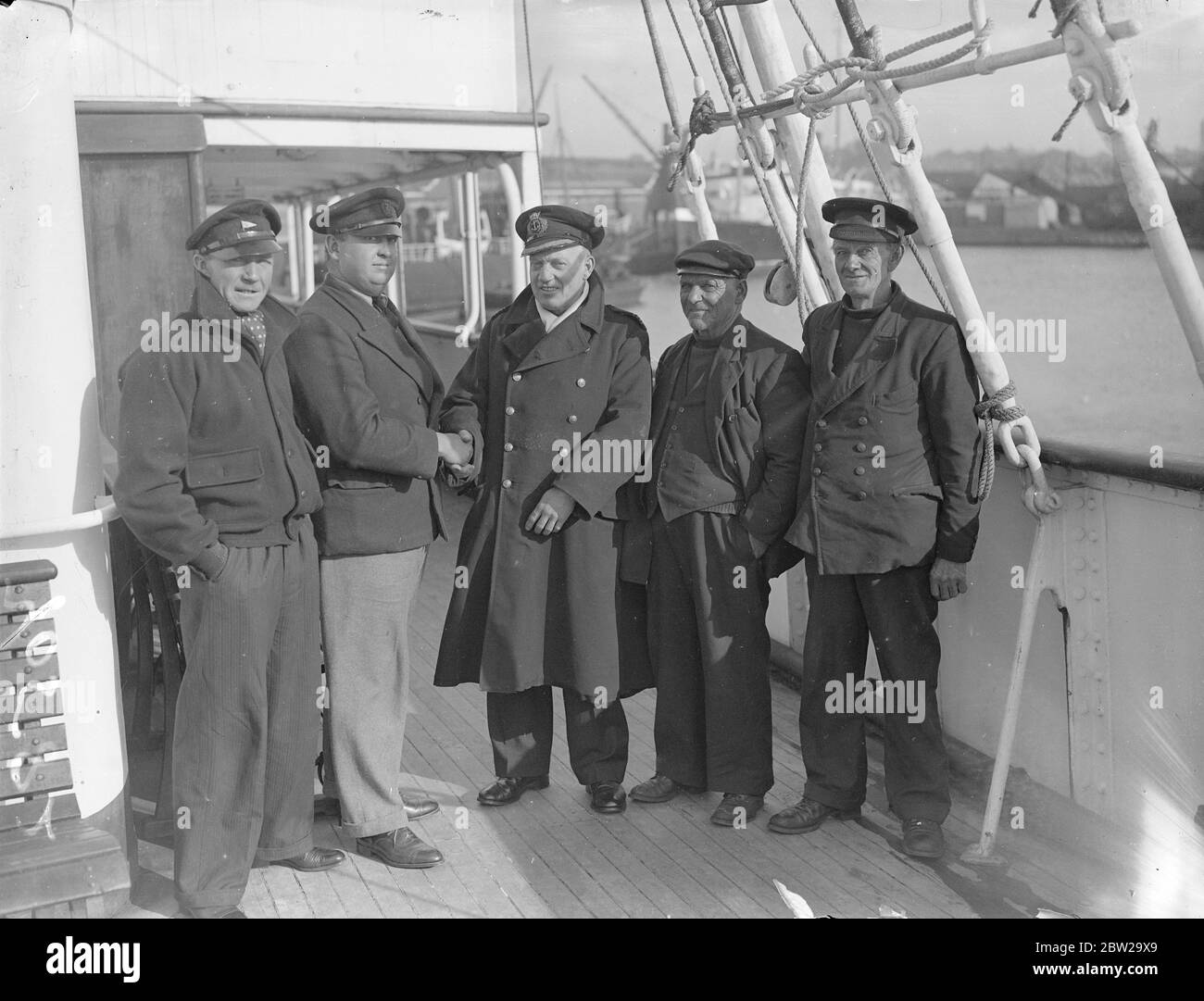 Foundered yachts crew at Southampton after mid-Channel rescue. Rescued by the steamer 'St Briac' when they yacht 'Tess' sank in the English Channel after a 10 hours fight with the gale, the crew of the yacht were landed at Southampton. They were on their way from Havre to Southampton when caught in the gale and despite their efforts with the pumps the yacht began to sink. They had to burn their beds to attract attention. Photo shows, the crew of the yacht 'Tess'on arrival at Southampton, Captain William Bennett, Mr Leonard Caven, John Starling and Mr P T MacBain. 24 October 1937 Stock Photo