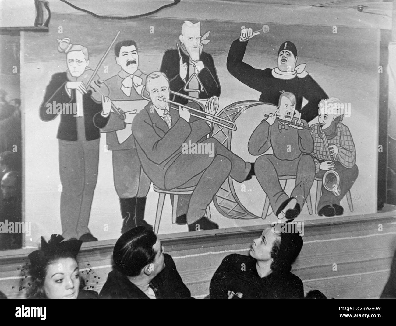 Duke of Windsor and president Roosevelt in 'swing band' the world's great cartoons at New York nightclub. When the 'Famous Door', a New York night club, reopened for the winter season, visitors were greeted by a mural of a swing band, the 'players' in which bore striking resemblance world-famous characters, including the Duke of Windsor and president Roosevelt. Photo shows, the 'swing band' mural at the Famous Door Club , depicting, left to right (behind) . The Duke of Windsor, Stalin, Bernard Shaw and Mussolini, beating the drum, in front. Left-to-right are president Roosevelt, Hitler and Pro Stock Photo