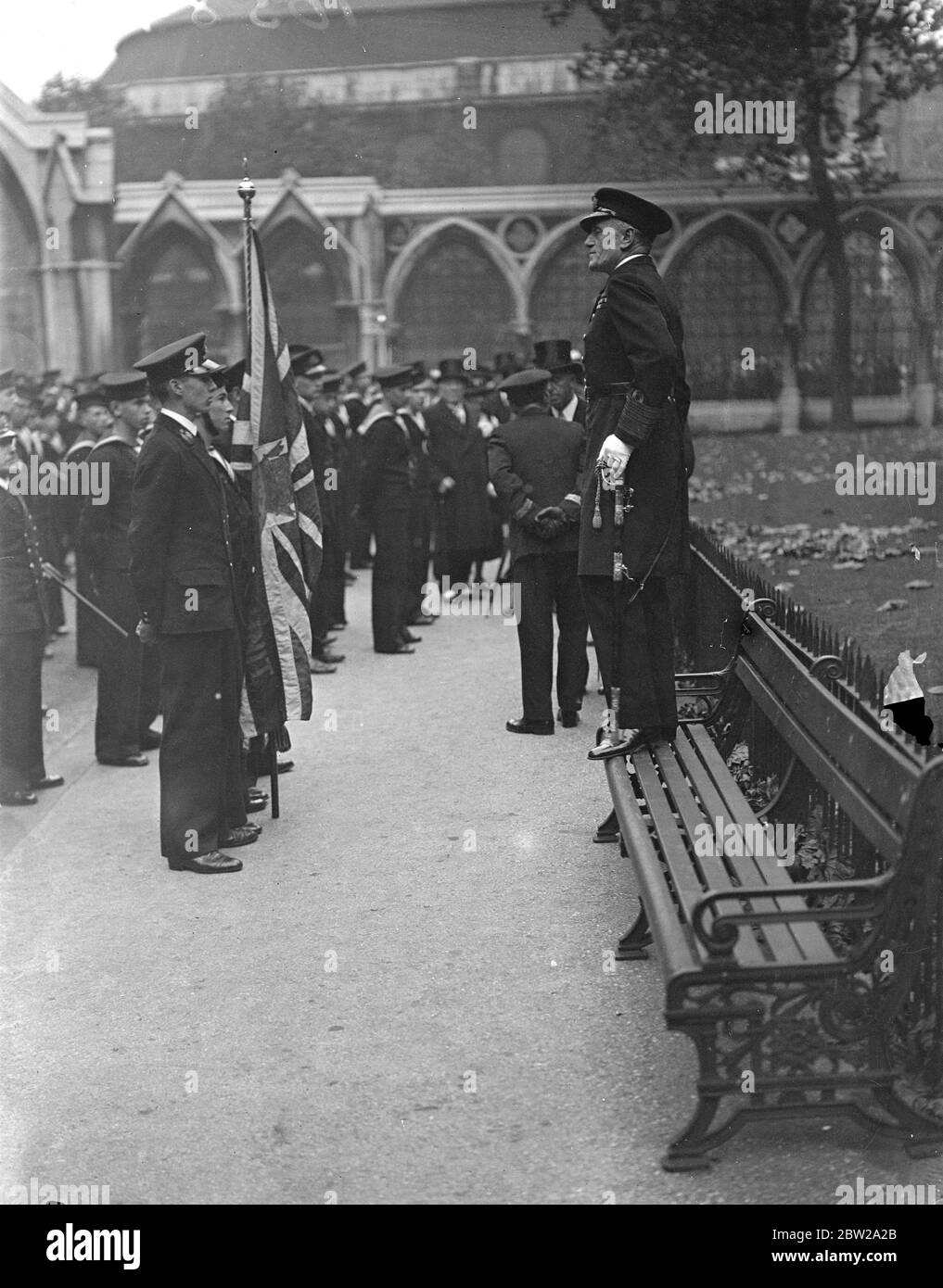 Adml uses garden seat to address naval cadets. Using a convenient garden seat beside the Law Courts, Adml Sir Martin Dunbar Nasmith, VC, addressed naval cadets after they had attended their annual service at St Clement Danes Church in the Strand, London.. Photo shows, Adml Sir Martin Dunbar Nasmith, VC, addressing the cadets from the seat beside the Law Courts. 24 October 1937 Stock Photo