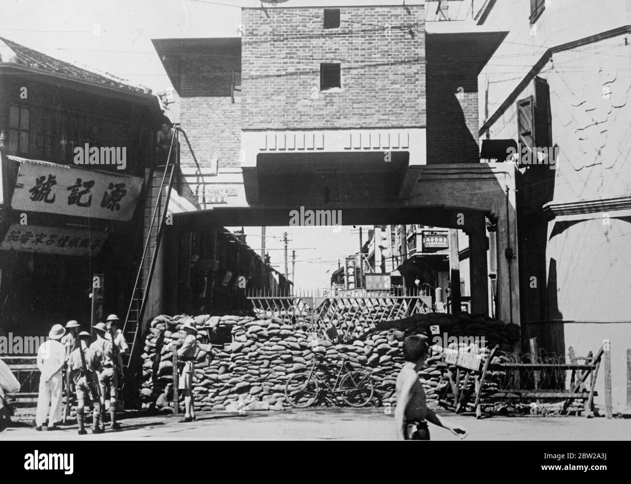 British blockhouse endangered as Japanese besiege Chinese 'doomed battlelion'in Shanghai. This picture, just received in London, shows, the British blockhouse held by the Welsh Fusiliers in north Thibet road, Shanghai, almost on top of the warehouse where the Chinese 'doomed battlelion', a refuse to retreat, besieged by 40,000 Japanese. The Japanese commander has notified the British post that he intends to bomb the isolated Chinese from the air and burn down their warehouse. The British soldiers have posted farewell letters handed to them by the Chinese, and some reports state that the Britis Stock Photo