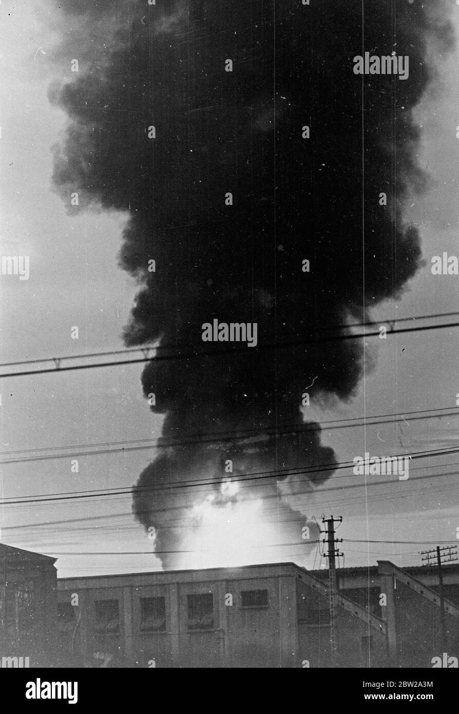 Japanese at the gates of Nanking. The fall of Nanking, the Chinese capital, is now reported to be imminent. It is said that Chinese resistance has completely collapsed and that the Japanese forces are now waiting outside the walls of the city to allow the remaining Chinese troops to evacuate before a formal entry is made. Photo shows, flames and smoke shooting skyward from a doomed building as the Japanese blasted their way towards Nanking. 7 December 1937 Stock Photo
