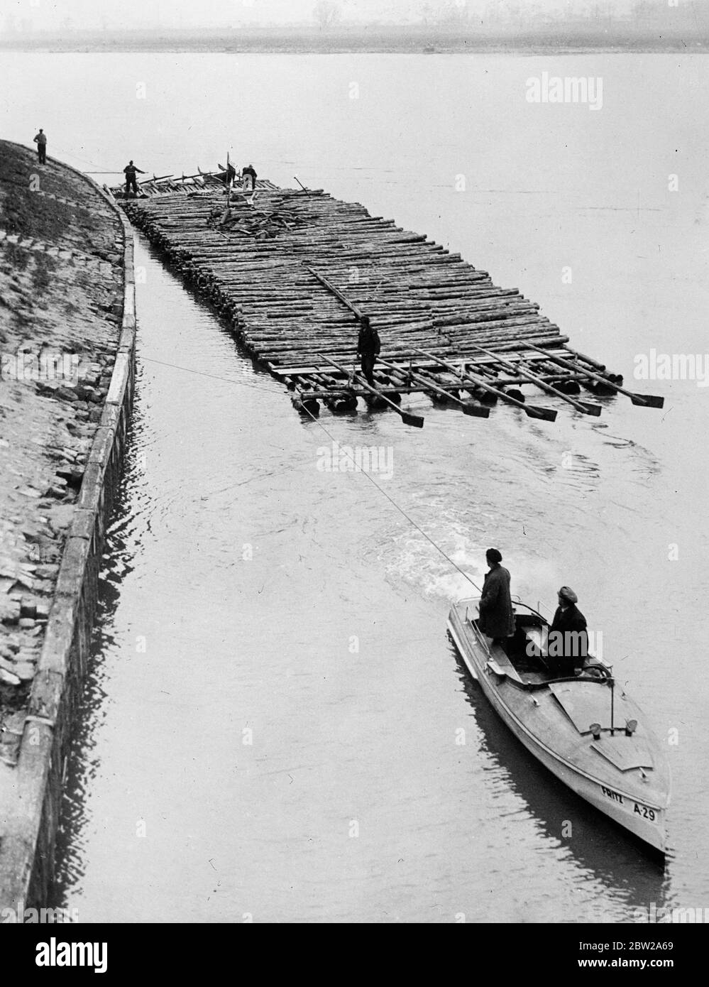 Island of timber on the Danube. The biggest timber raft seen on the Danube for several years, floated down the river from Rossatz to Vienna. The giant raft was over 150 feet in length and about 20 feet wide. Photo shows, though raft nearing Vienna after his journey down the Danube. 29 November 1937 Stock Photo