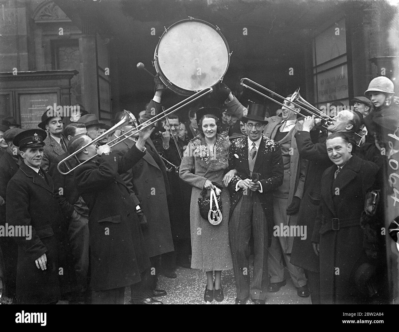 Alfred Van Dam married at Caxton Hall, band performed guard of honour. The bridegroom's band formed a guard of honour outside Caxton Hall register office, London, when Mr Alfred Van Dam, leader of the band at the Trocadero cinema, Elephant and Castle, was married to 27-year-old miss Dorothy Gascoyne of Kentish Town, London. The bride met her future husband after being 'discovered' by Carroll lavis of the BBC's amateur hour. Photo shows, the bride and groom after the ceremony. 18 December 1937 Stock Photo