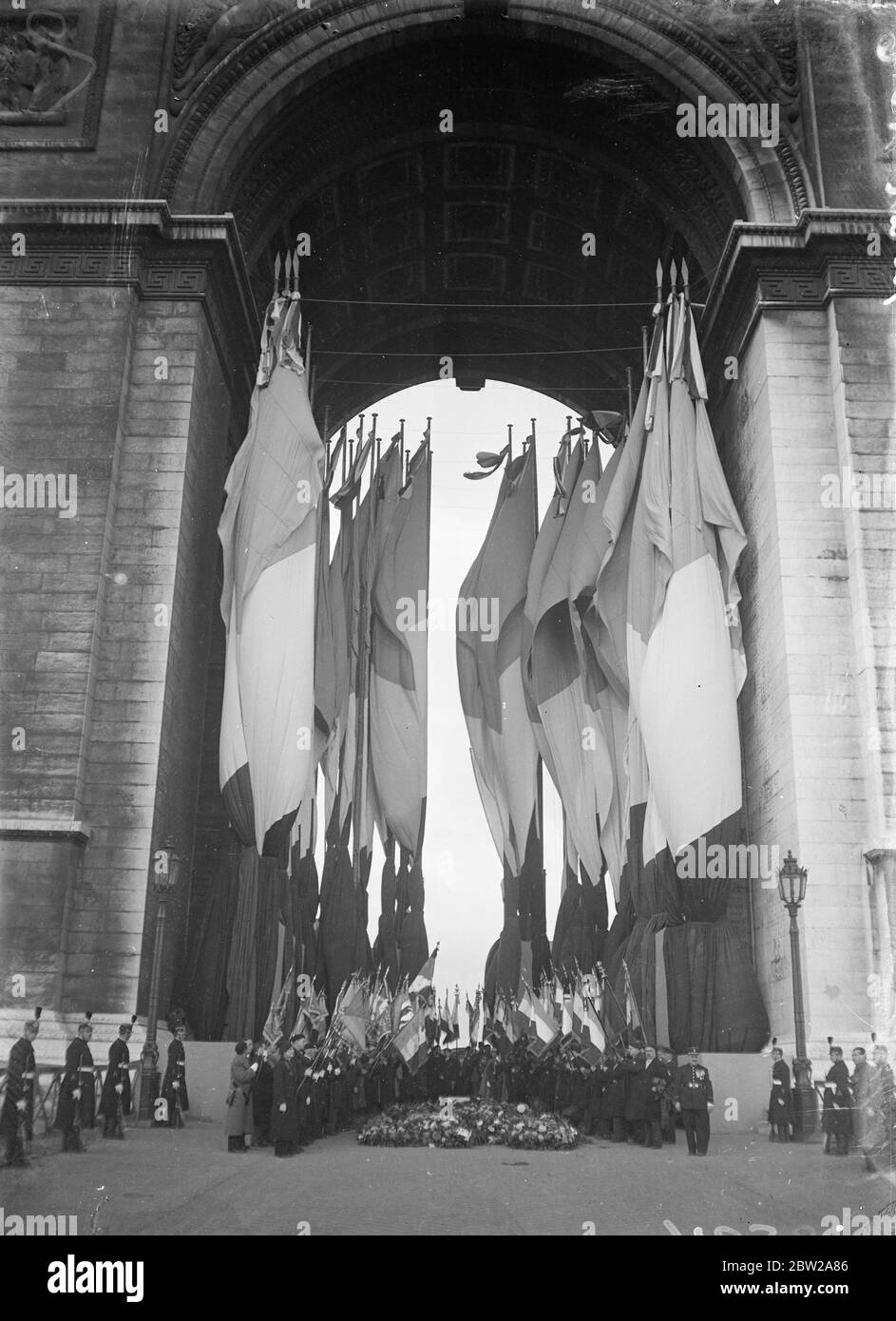 War regiments standard on the Arc de Triumphe President LeBrun, with members of the Cabinet and ex-servicemen, attended the Armistice Day service at the Arc de Triumphe in Paris. Photo shows, ex-servicemen flags and standards of dissolved regiments on the Arc de Triumphe during the service. 11 November 1937 Stock Photo