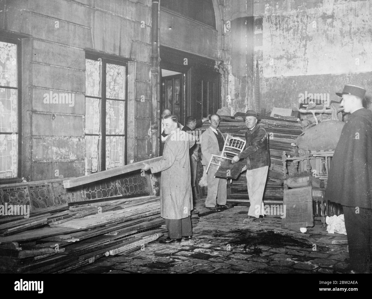 Nationwide search in France for secret arsenals. Detectives engaged in a nationwide search are discovering more and more secret arsenals following the disclosure of the gigantic arms plot of the Cagoulards (Cowled Men) in France. 18 of the ring leaders have been arrested and the Surete Nationals (French Scotland Yard) assert that the names of all important members implicated are Known. Photo shows, detectives making a search for secret arsenal in the Rue Rotrou, Paris. 21 November 1937 Stock Photo