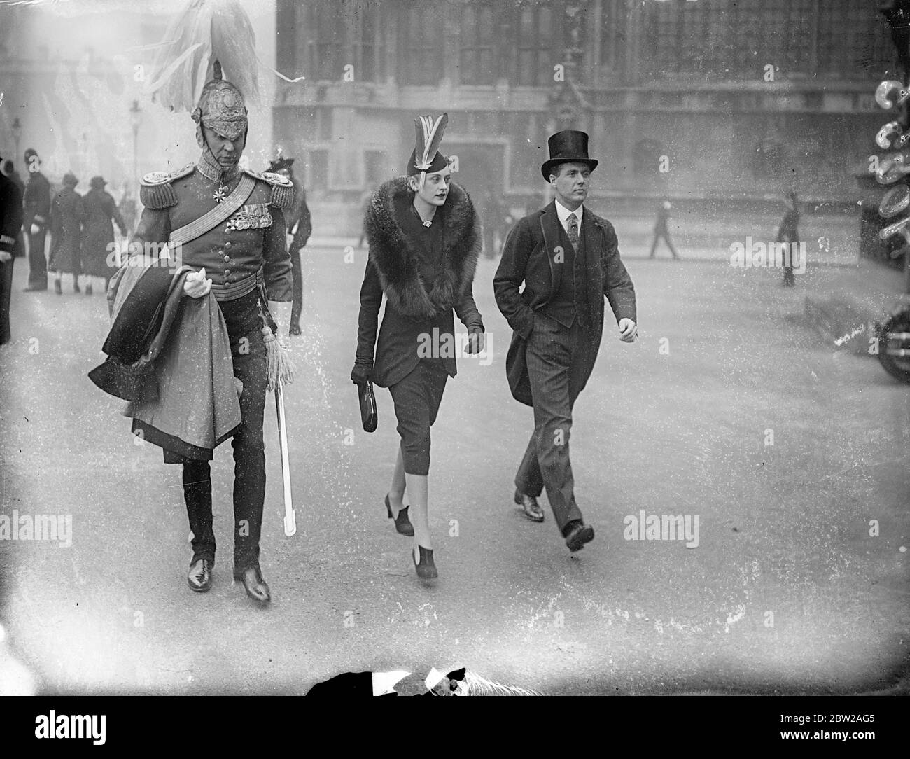 Hat fashion at State Opening of Parliament. A striking hat fashion, worn by an arrival for the state opening of Parliament by the King. Photo shows, Col Ulric Thyne (left ) and Mrs Murray Smith. 26 October 1937 Stock Photo