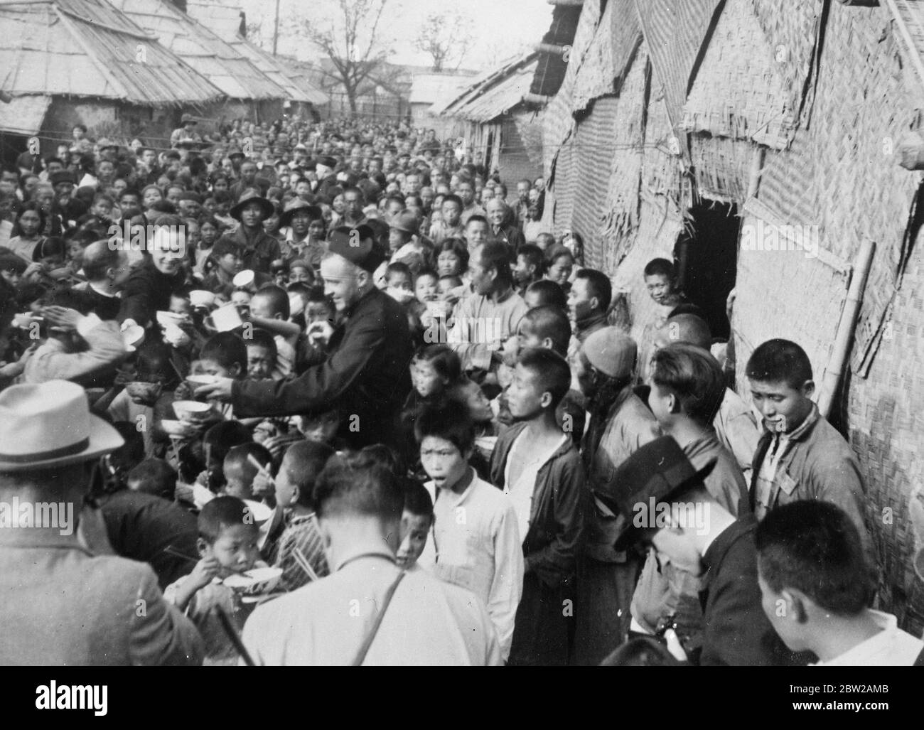 Priests feed thousands of Chinese children in Shanghai. Thousands of Chinese refugee children are being cared for by priest at Siccawei Cathedral in the south-west of the French Concession at Shanghai. The young refugees are fed, housed and given medical attention by the priests. 2 December 1937 Stock Photo