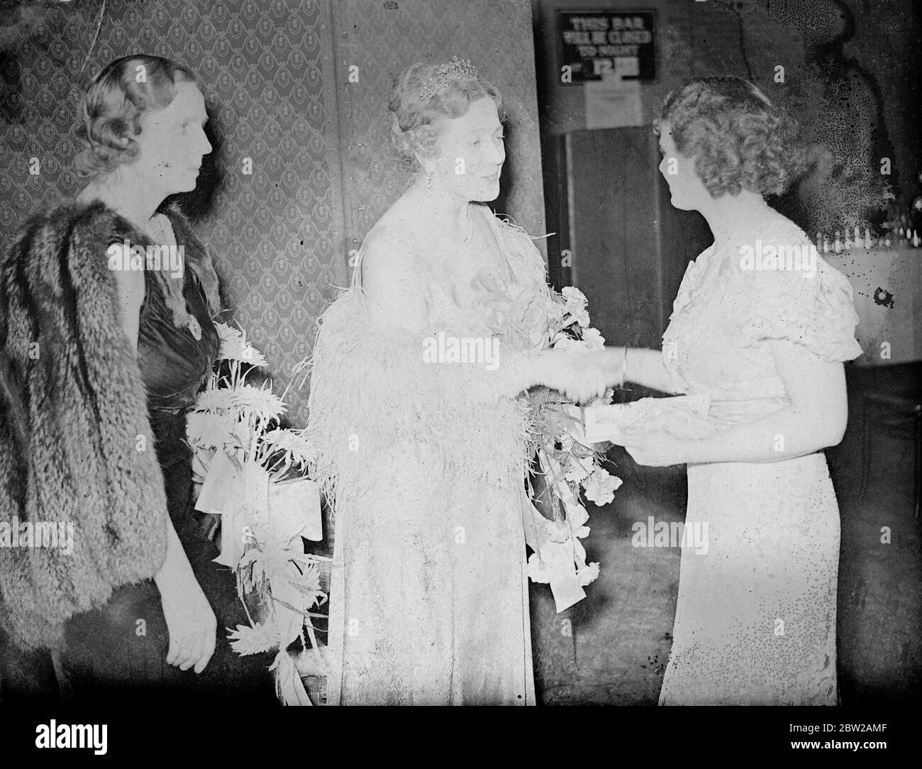 Premier's wife receives guests at London Conservatives gigantic Christmas party. Miss Neville Chamberlain, wife of the Premier acted as hostess to 2000 guests who attended the London Conservatives Christmas party at the horticultural Hall, Westminster, London. In this party, new to London. Conservatism, famous sportsmen and film actors helped to run a funfair. Funds raised will be used to help poorer constituencies. But the shows, Mrs Neville Chamberlain, receiving a guest at the party. On left is the Lady Lucas Tooth (chairman of the party committee). 8 December 1937 Stock Photo