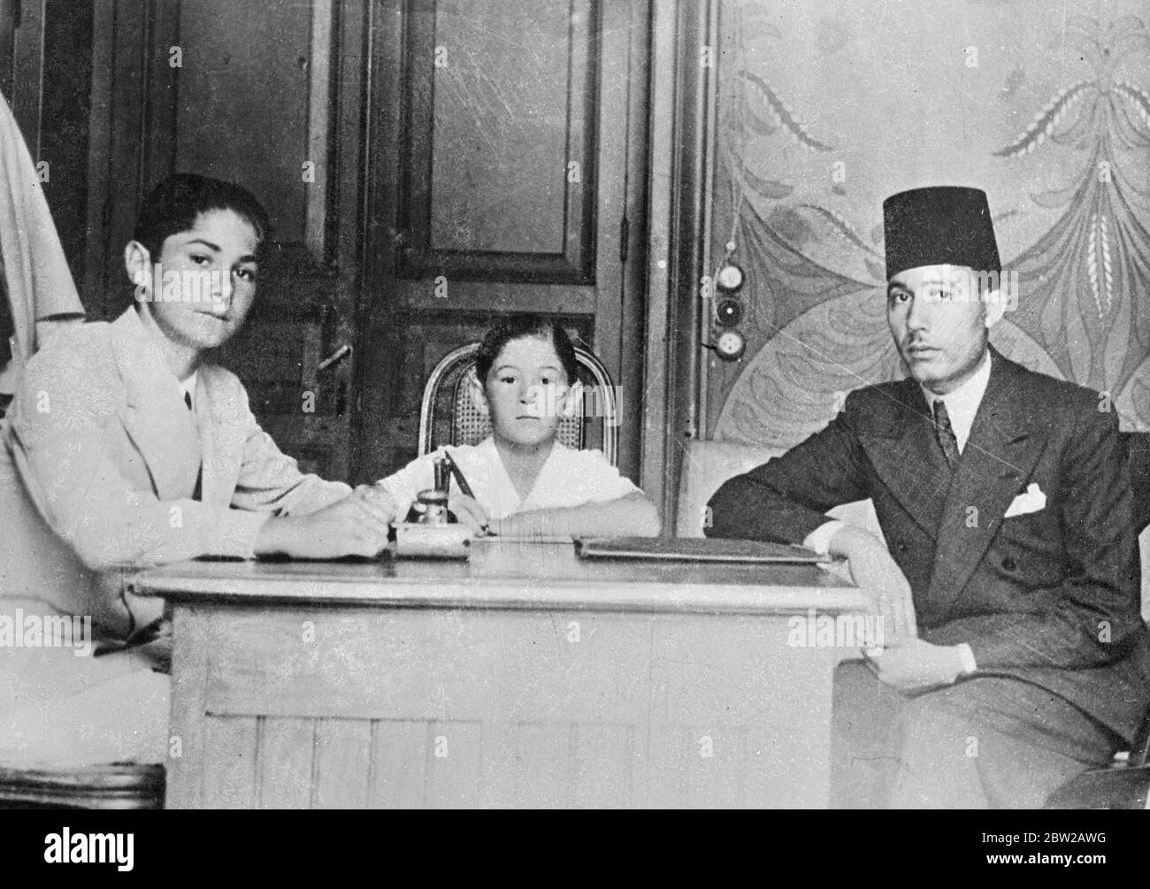 Brothers of King Farouk's fiancee wedding in January. The brothers of Mlle Farida Zulficar, fiancee of the young King Farouk of Egypt, with their private tutor. The wedding of the boy king will take place in the first week of January 1938, at Montaza Palace, his summer residence near Alexandria. Stock Photo