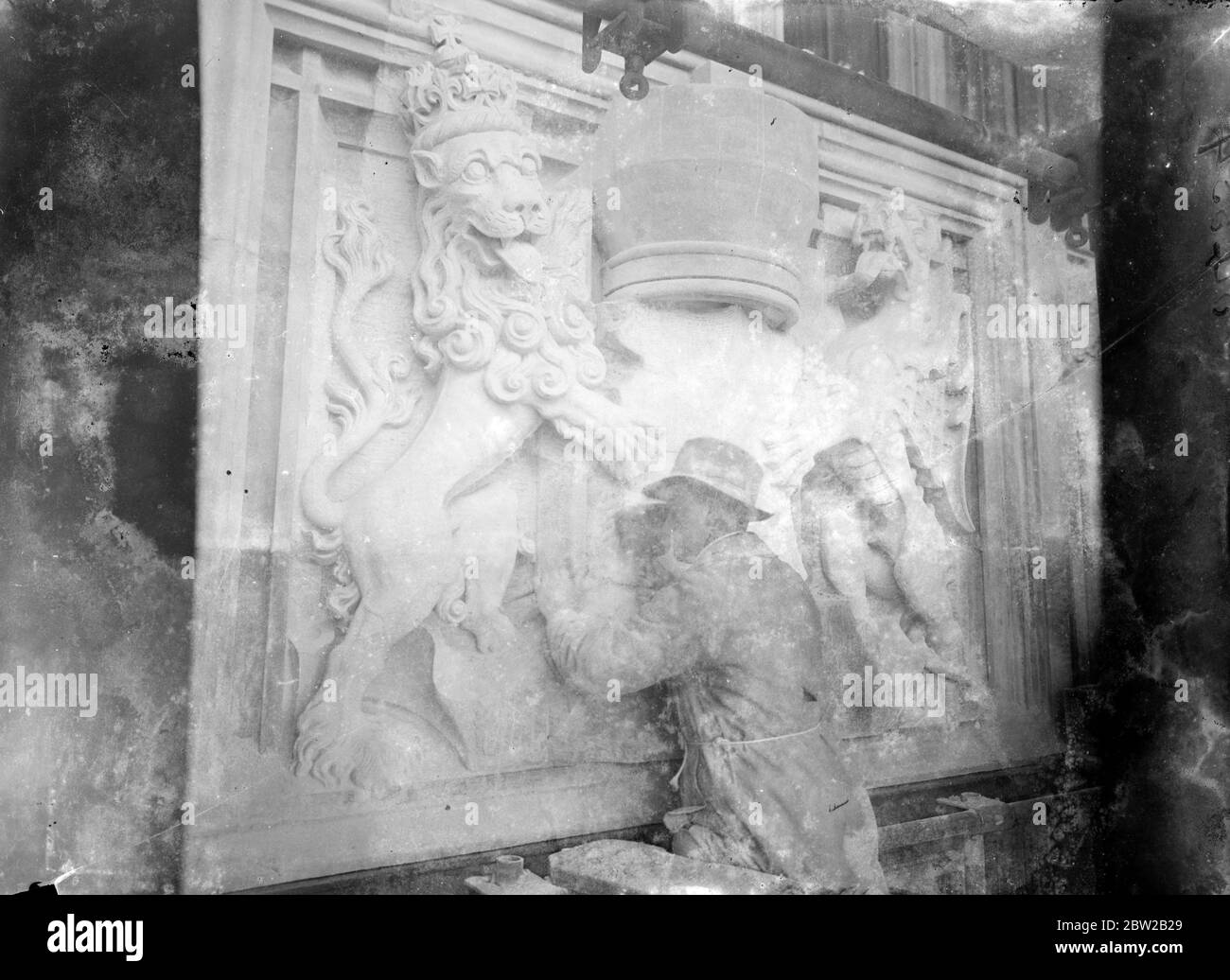 A sculptor working on a heraldic base relief [Royal Supporters of England / Royal Arms of England. [Lion and Dragon] 30s Stock Photo
