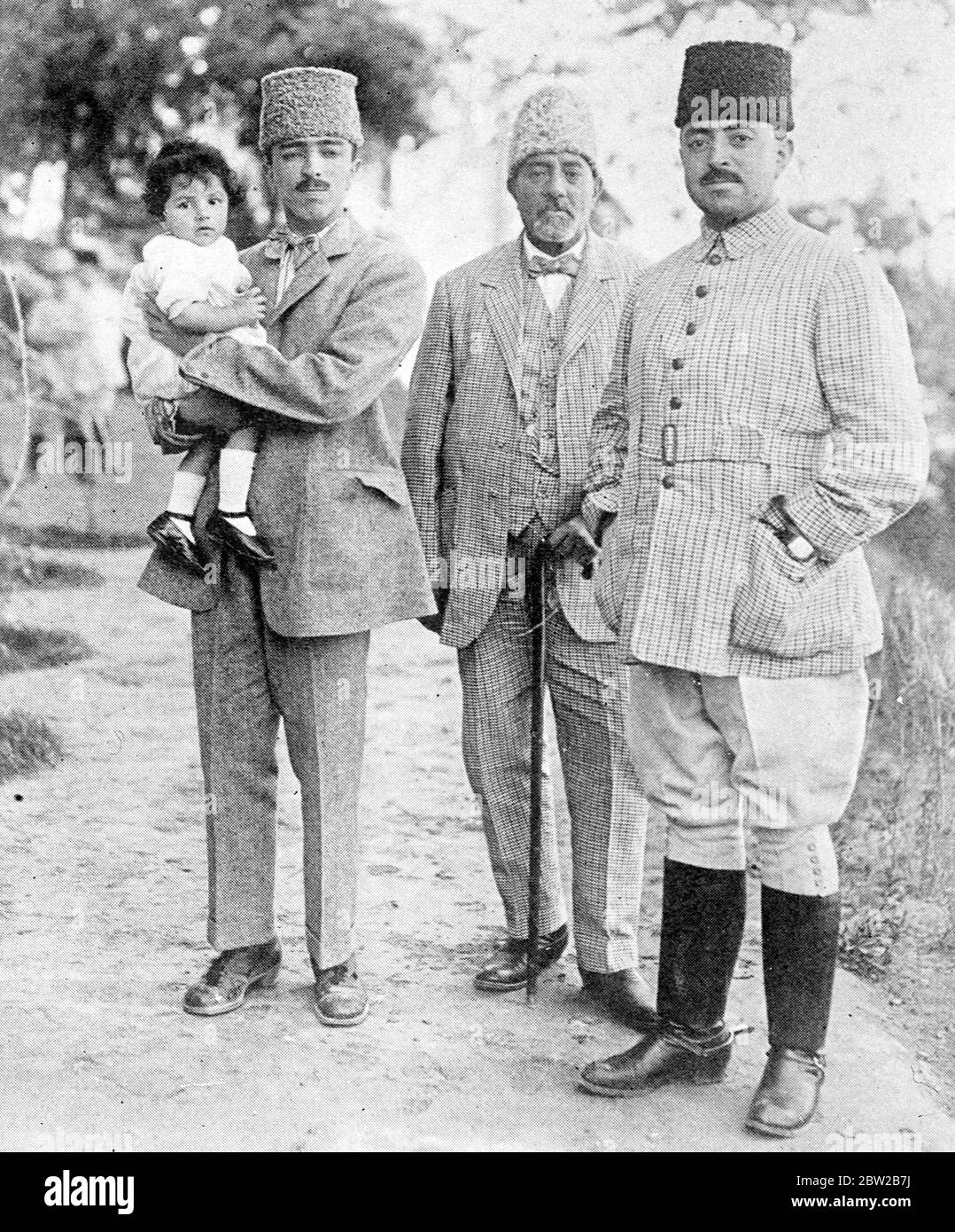 The Amir of Afghanistan (right) with his father in law (centre) and Prince Mhaommed Kabir Kabir Khan, the Amir's brother, who is holding the latter's younger son in his arms. 2 December 1927 Stock Photo