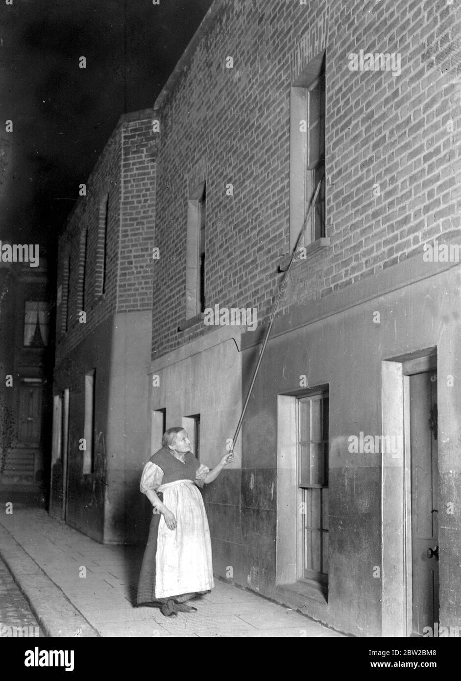 Mrs Matilda Marks, who starts her round of knocking up at 2 A.M., she will be 85 next March, what she earns by this means and her earnings from sewing during the day enables her to keep two orphan grandchildren who would otherwise be in the workhouse. 1914 - 1918 Stock Photo