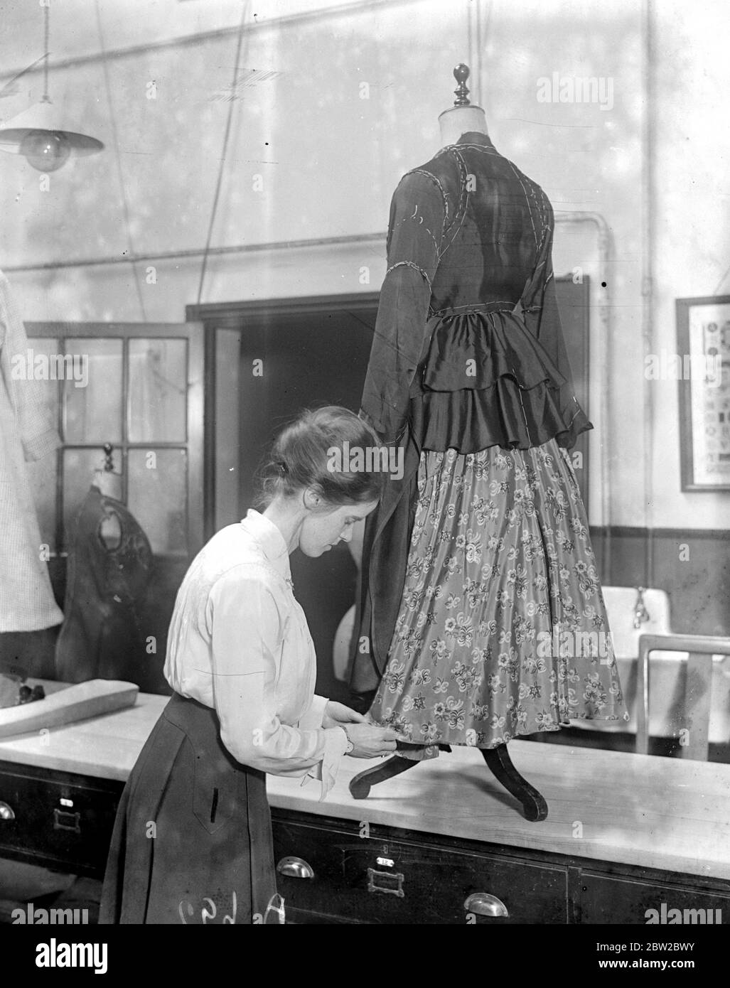 The Northern Polytechnic has started classes to enable women to convert out of date costumes into fashionable creations. There by enabling them to dress fashionable and economise at the same time. Costume made form an old cape, a skirt and a small piece of new material. 1914 - 1918 Stock Photo