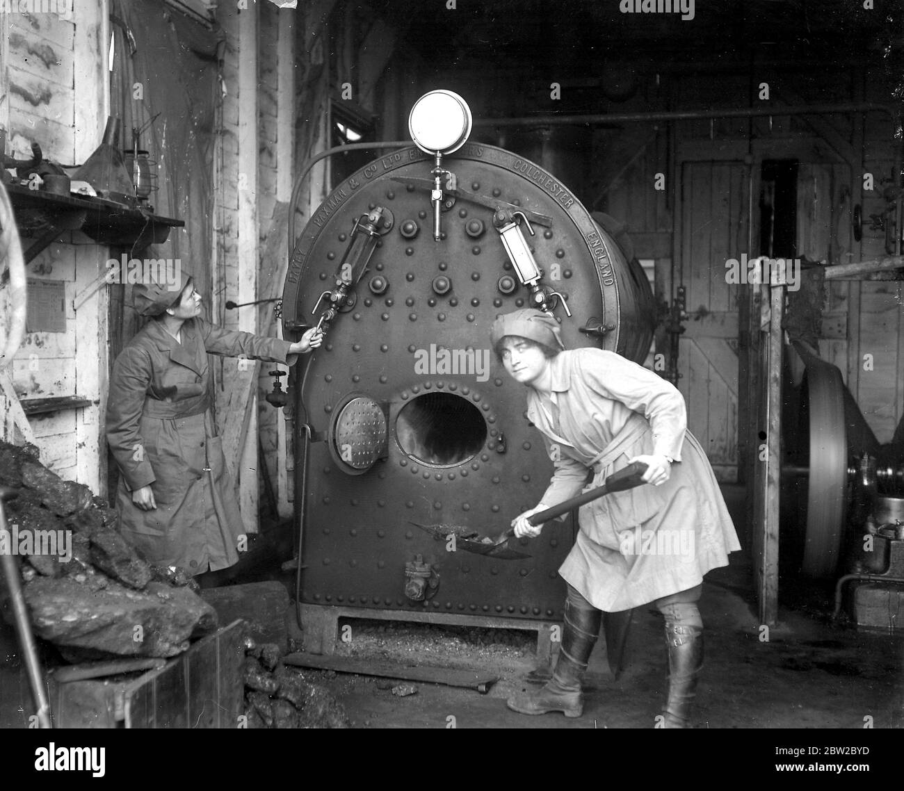 Old hop kilns used in a new village industry in kent - A vegetable drying factory has been organised by the ministry of food, where women are taught to dry all sorts of vegetables in case of any shotage during the coming spring.Stoking up the boilers. 2nd Feburary 1918 Stock Photo
