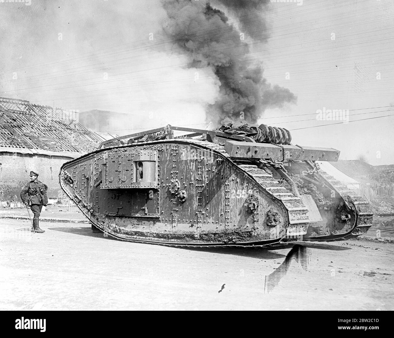 A Mark IV Tank passing a burning bridge, Peronne. 23rd March 1918 Stock Photo