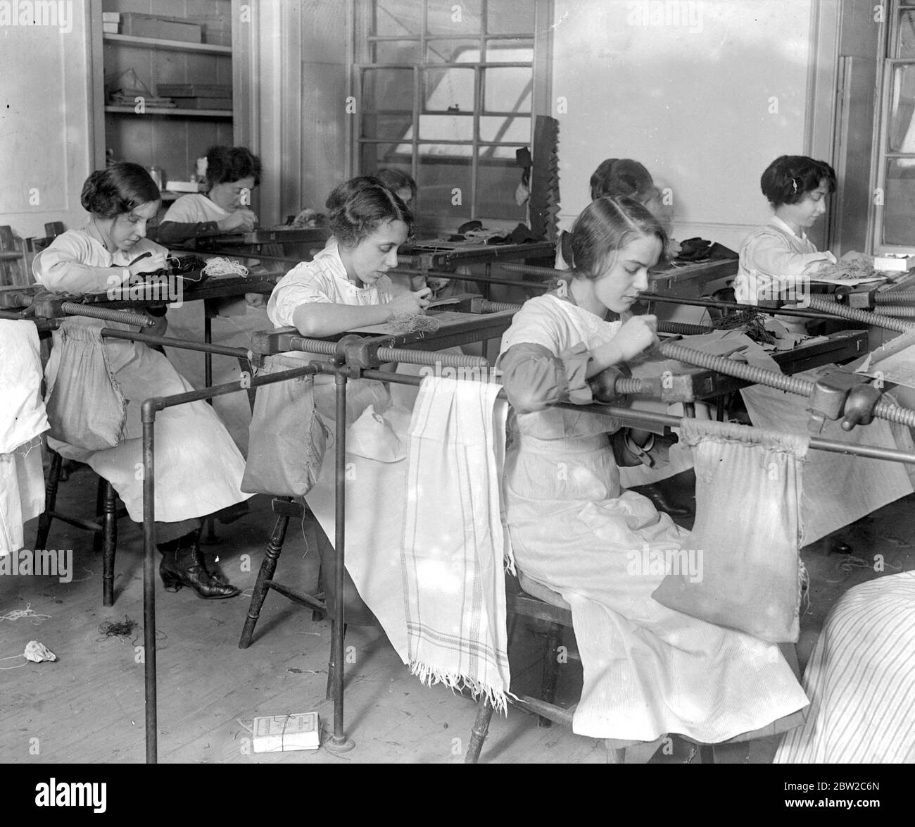 Girls at their regular occupations. Making military badges - at Messrs George Kenning. 1914 - 1918 Stock Photo