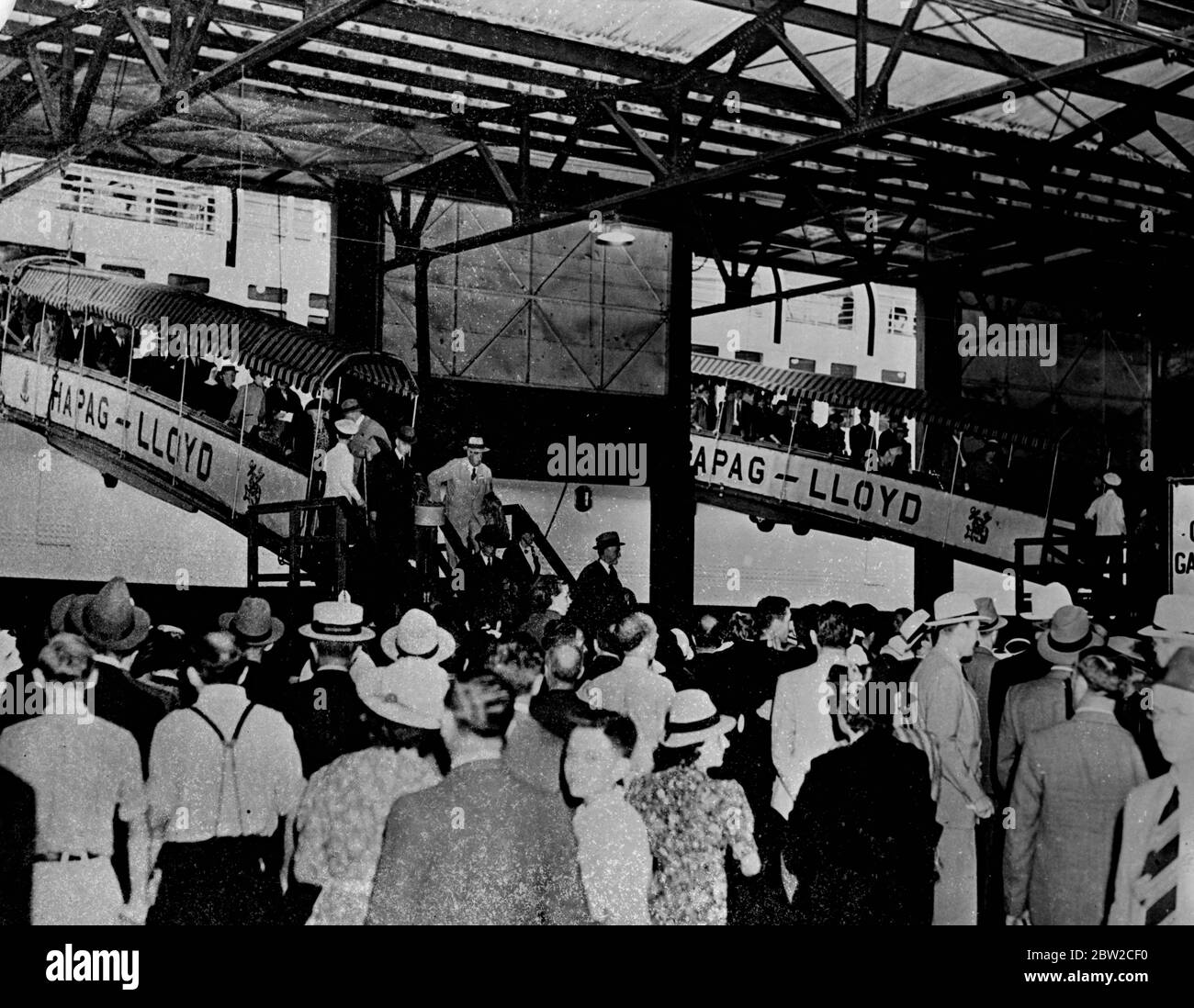Passengers disembark from the North German Lloyd liner Bremen on her arrival here, August 28 after the liner, under orders of the German Admiralty, had refused to answer radio messages for the past few days. Most of the 1600 passengers were Americans fleeing from possible war. 29 August 1939 Stock Photo