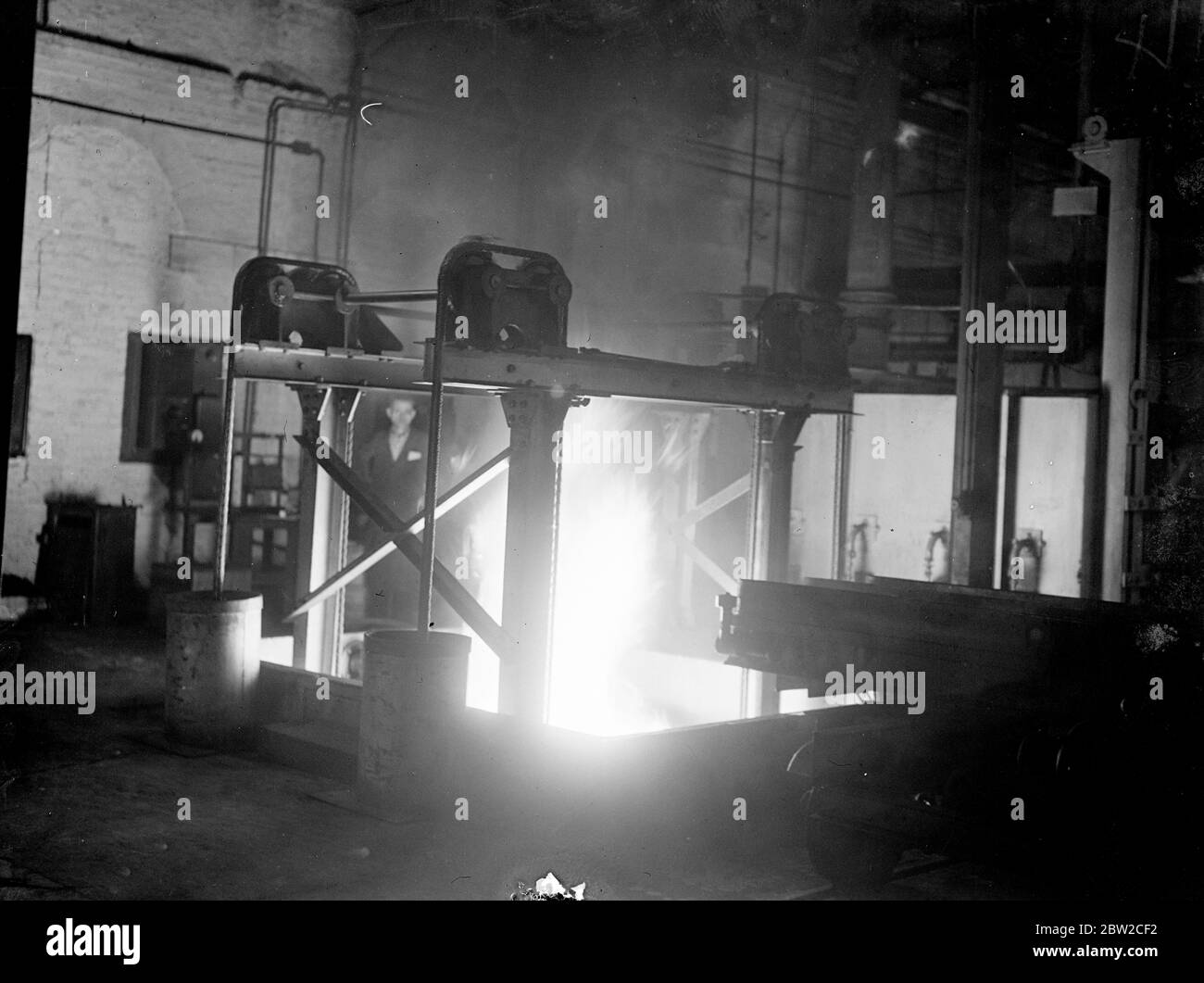 The glare of a blasting furnace at a British shell factory - one of Europe's largest - somewhere in England, where men are working day and night to fulfil orders for the Ministry of Supply. 13 November 1939 Stock Photo