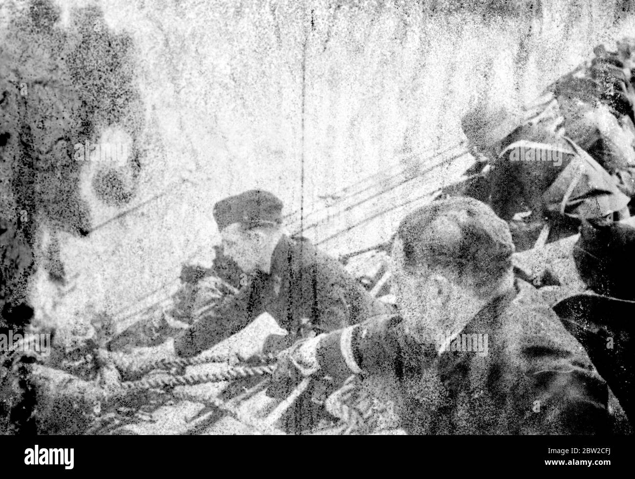 British sailors being hauled aboard a German warship after their vessel had been sunk in a battle against heavy odds. 24 April 1940 Stock Photo