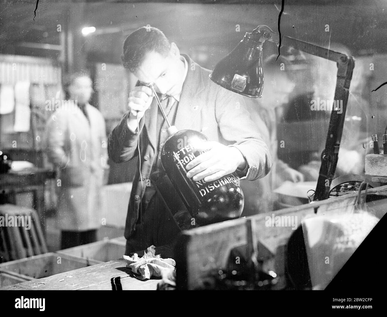 Testing an oxygen cylinder at a shell factory - one of Europe's largest - somewhere in England, where men are working day and night to fulfil orders for the Ministry of Supply. 18 November 1939 Stock Photo