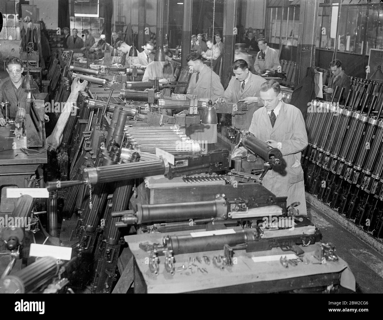Turning out small arms by the thousand in a British factory. These pictures were made in a Royal Ordinance factory of the Ministry of Supply specialising in the production of small arms. Here, thousands of weapons such as machine guns, rifles and revolvers are being turned out at a high speed for the use of Britain's rapidly growing force. Photo shows Vickers machine guns in the making. 15 November 1939 Stock Photo